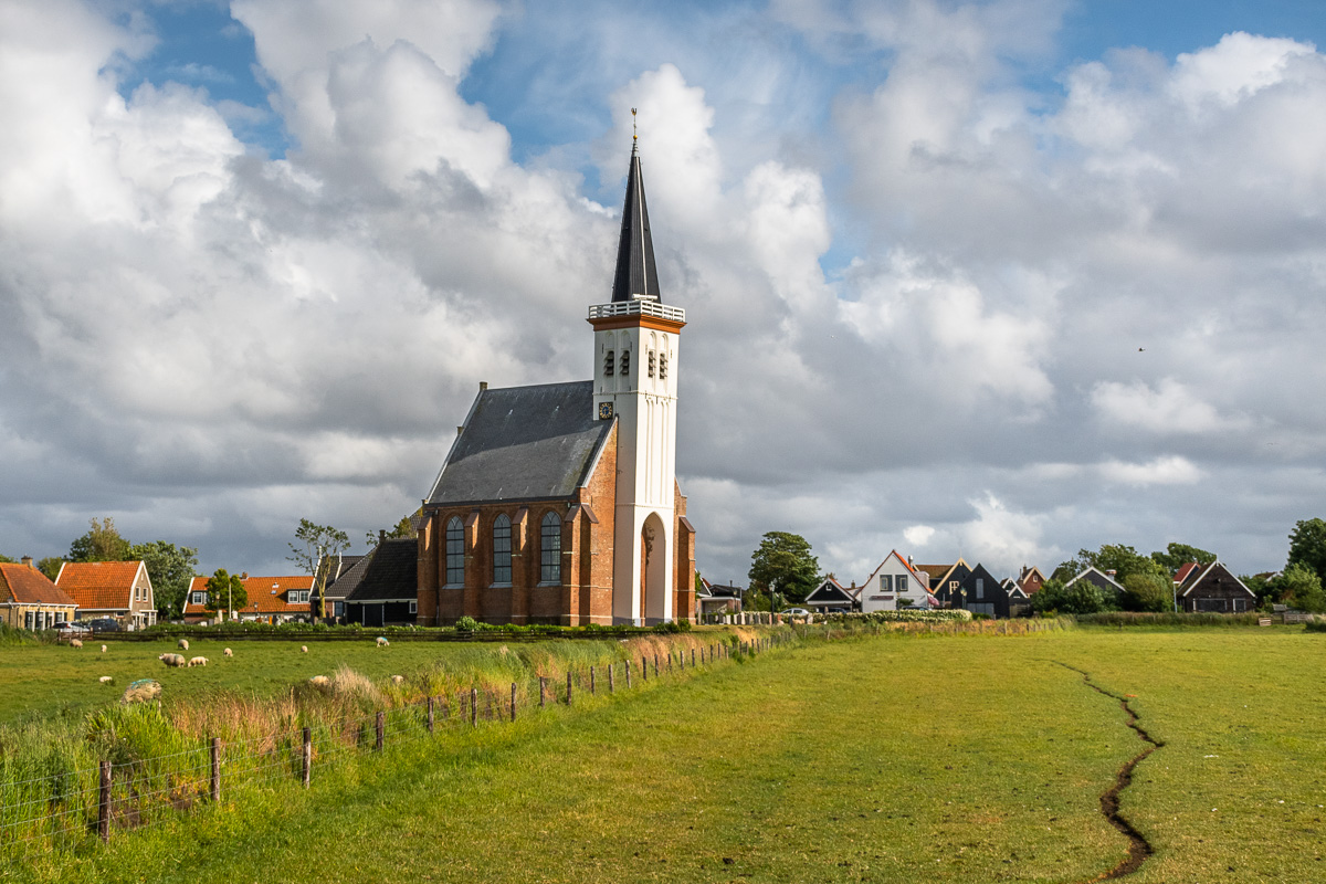 Hübsche Kirche vor einer saftig grünen Wiese auf Texel