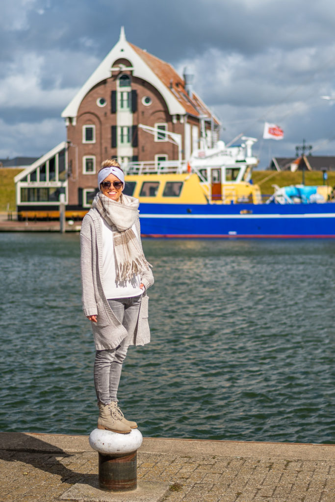 Frau steht am Hafen der Nordsee auf Texel