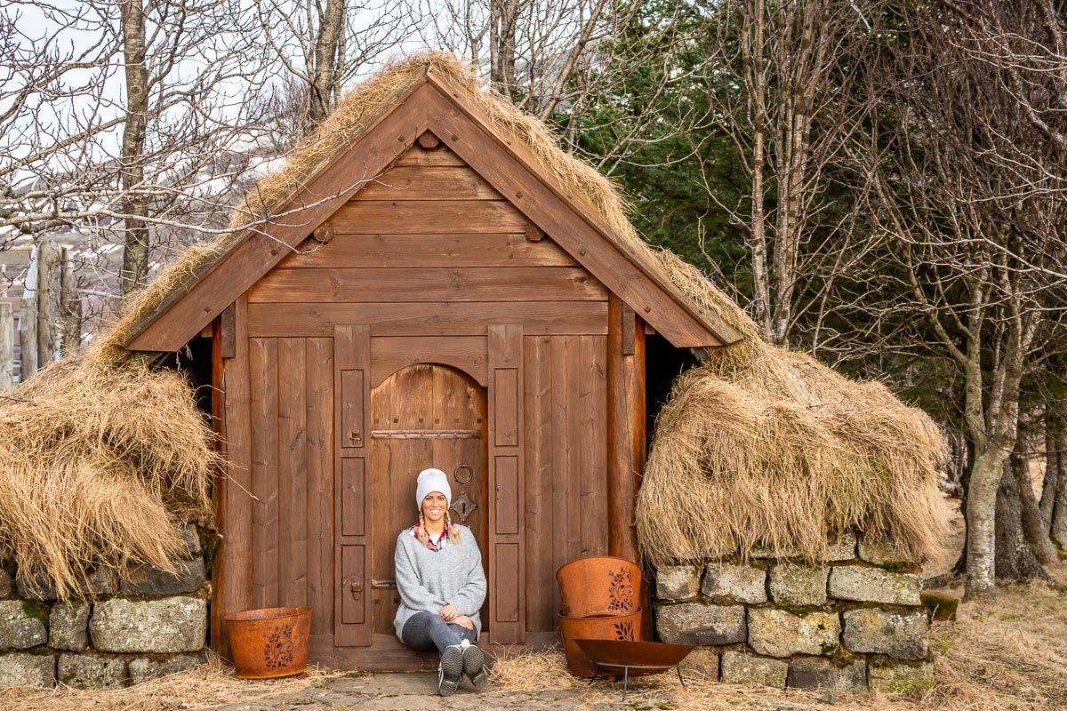 Frau sitzt vor einer Holzhütte und denkt an das Ende der Reise