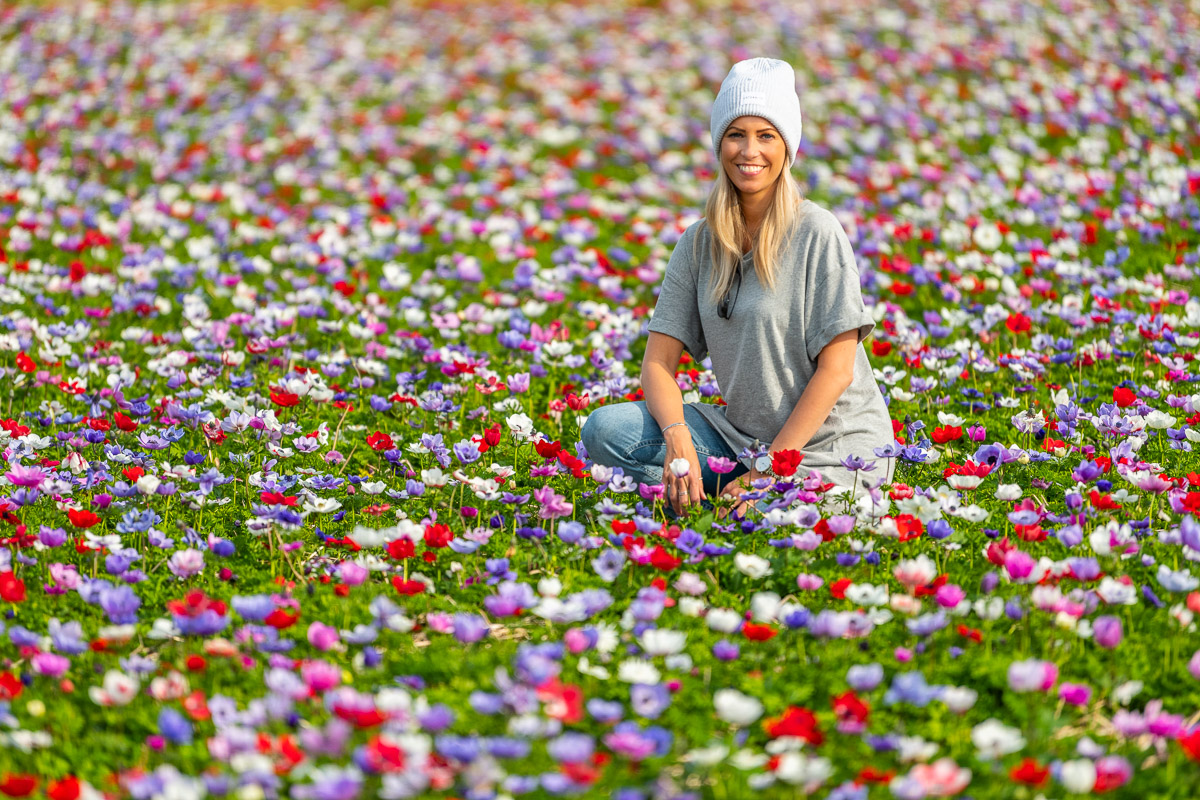 Frau sitzt in einer bunten Blumenwiese auf Texel