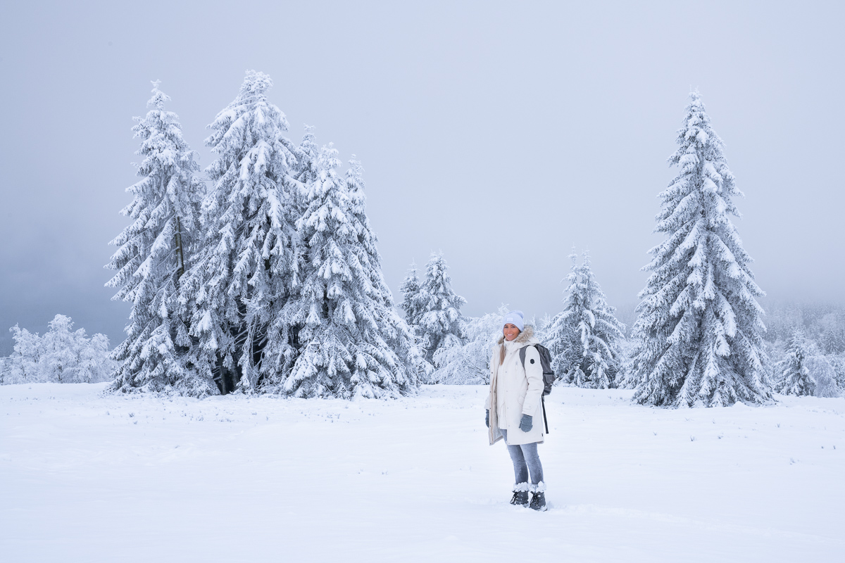 Frau steht in einer Schneelandschaft