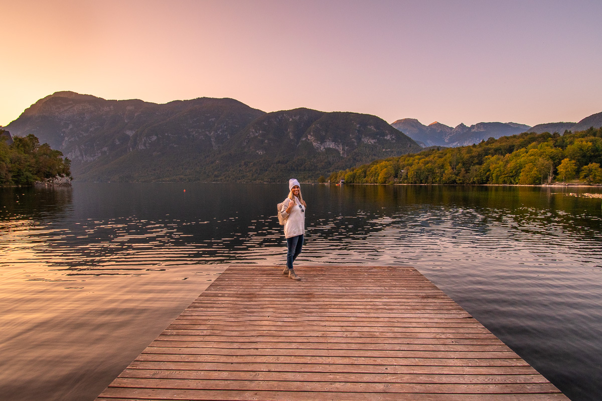 Frau steht auf einem Steg am See