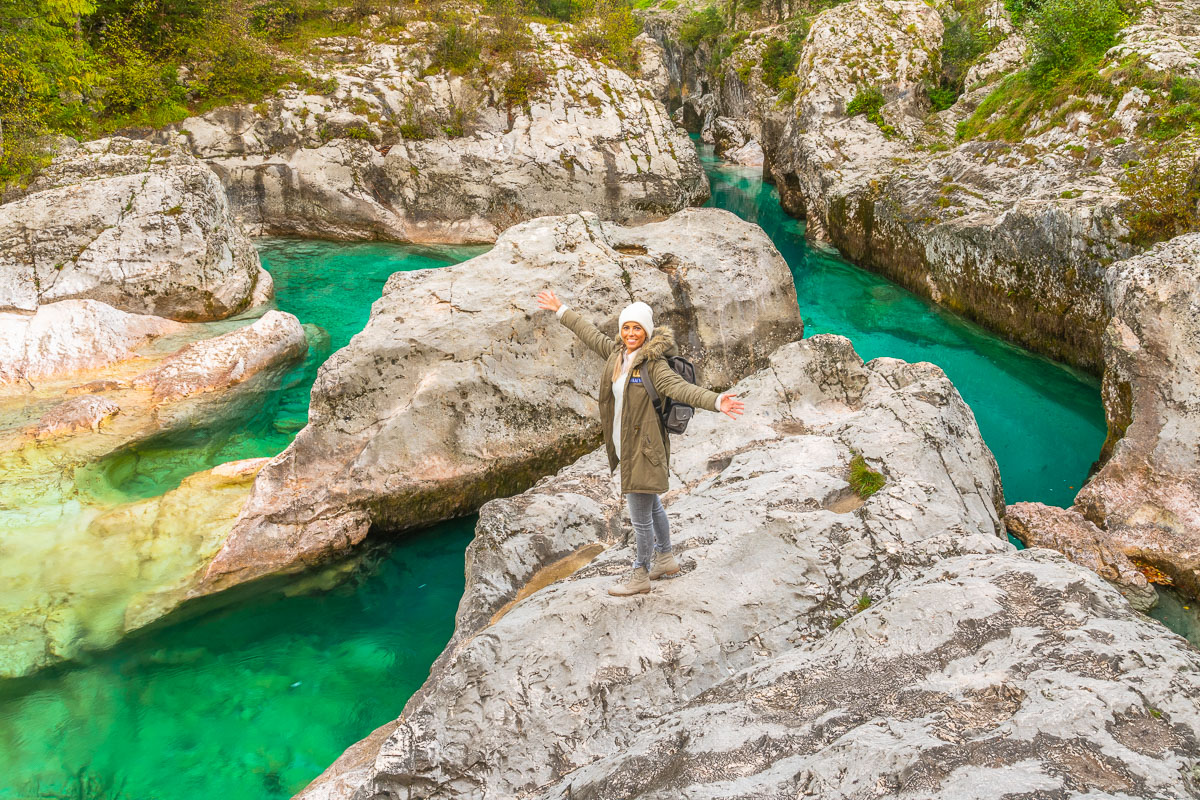 Frau steht im Socatal in Slowenien vor türkisem Wasser