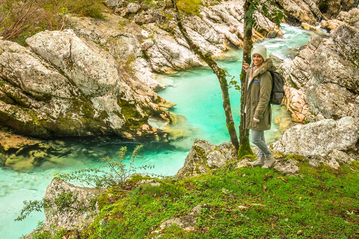 Frau steht an dem Fluss Soca in Slowenien